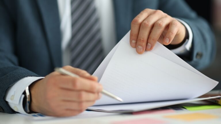 man in suit holding documents in his hands