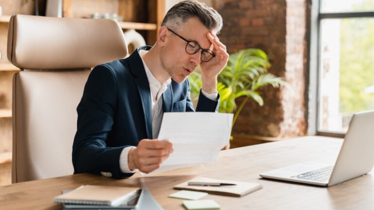 upset businessman looking through documents